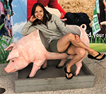Elena Karlsen-Ayala sitting on a fake pig