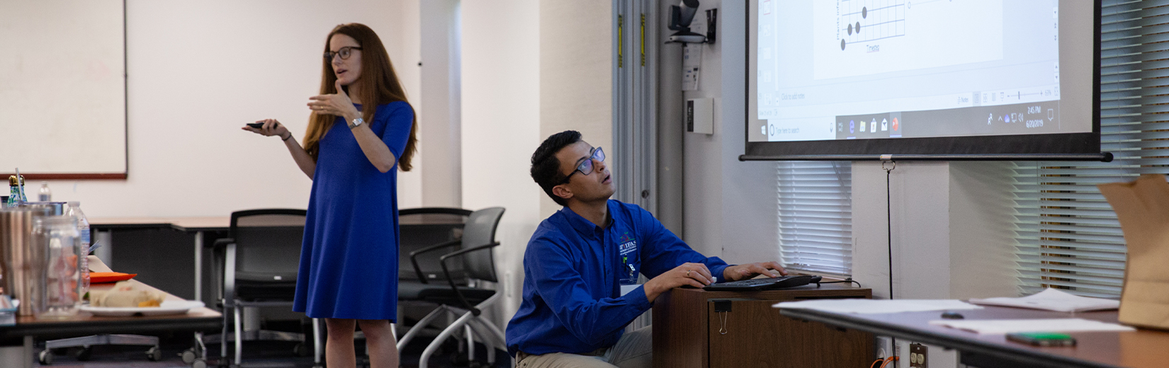 Graduate students Kelsey Andersen and Rodrigro Onofre present information to guests